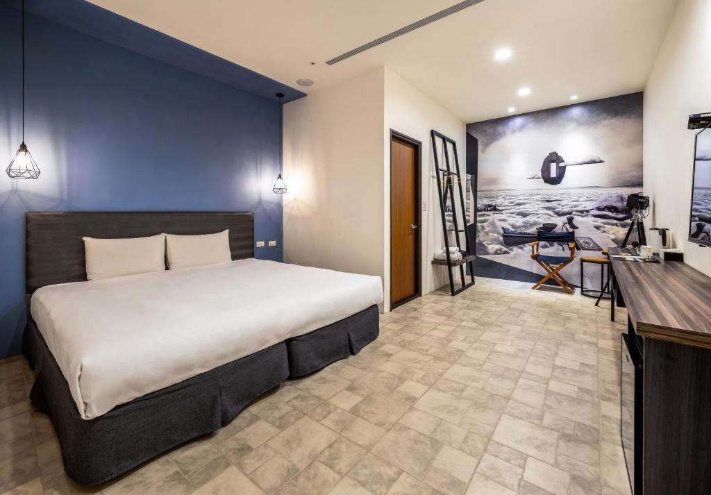 a bedroom with a large bed and a desk at 凝萃文旅 台中車站店 NCH-Business Hotel in Taichung