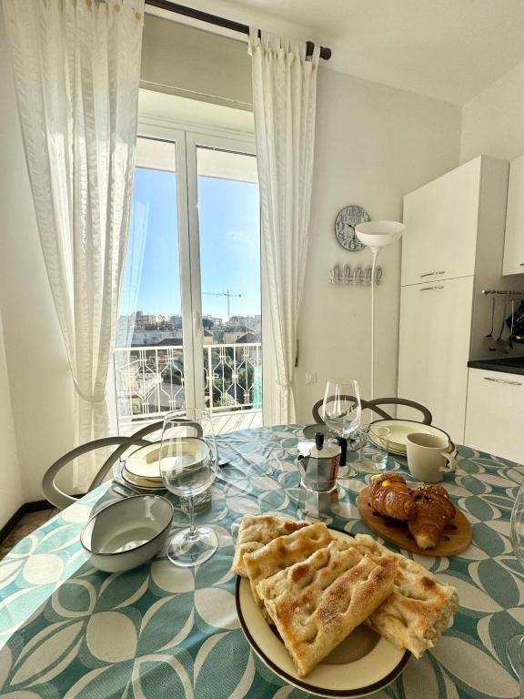 a table with a plate of food and wine glasses at Casa Dante in Finale Ligure