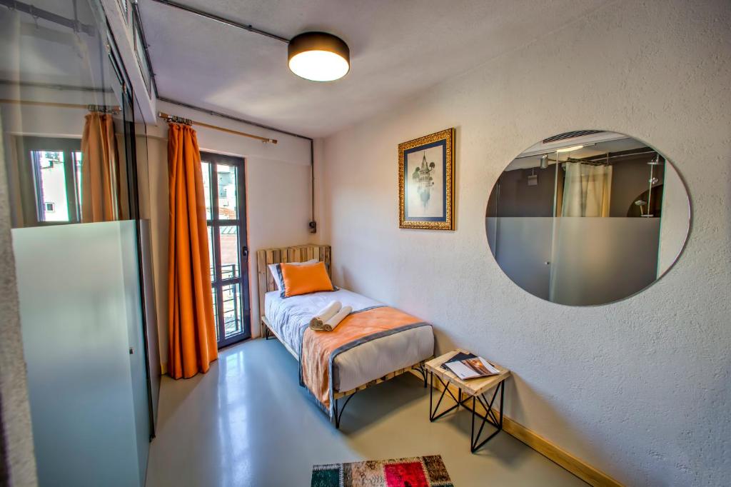 イスタンブールにあるVavien Hotelの小さなベッドルーム(ベッド1台、鏡付)