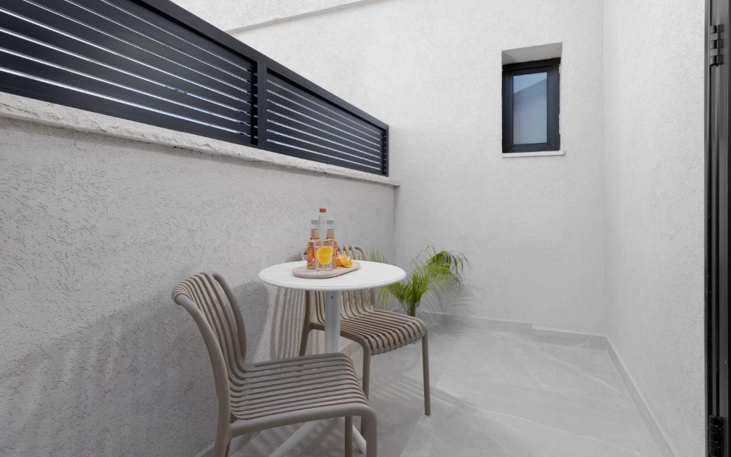einen kleinen Tisch und zwei Stühle auf einer Terrasse in der Unterkunft אורה דירות אירוח -נץ 9- דירות נופש איכותיות לנופש שקט ואקסלוסיבי in Eilat