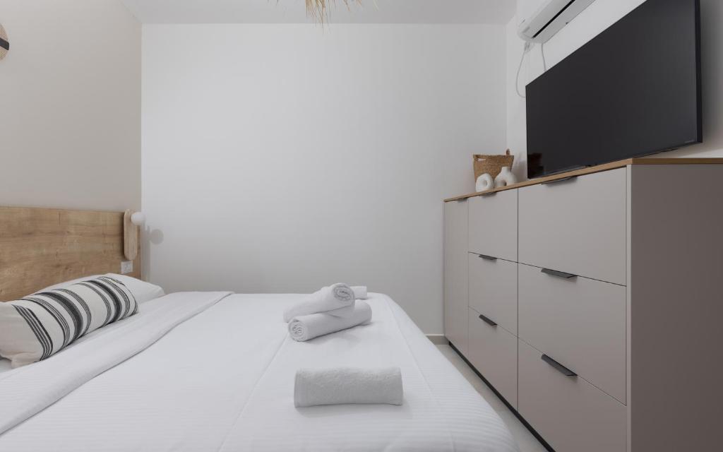 ein Schlafzimmer mit einem Bett und einem Flachbildfernseher in der Unterkunft אורה דירות אירוח -נץ 9- דירות נופש איכותיות לנופש שקט ואקסלוסיבי in Eilat