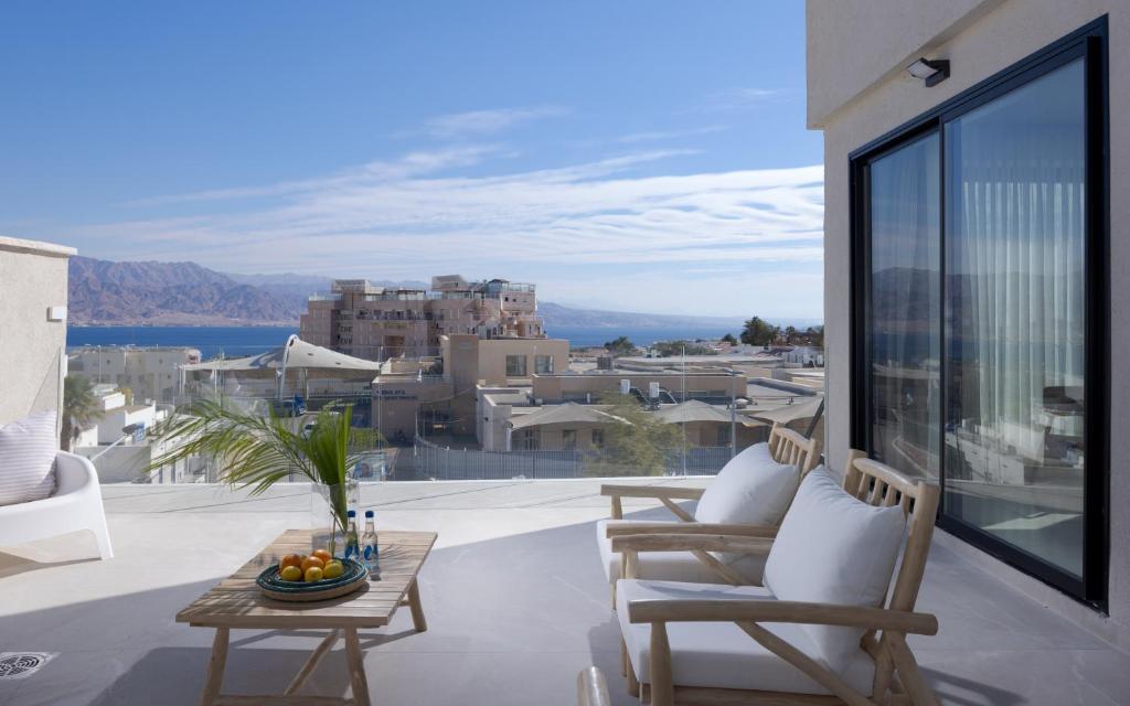 eine Terrasse mit Tisch und Stühlen auf einem Balkon in der Unterkunft אורה דירות אירוח -נץ 9- דירות נופש איכותיות לנופש שקט ואקסלוסיבי in Eilat