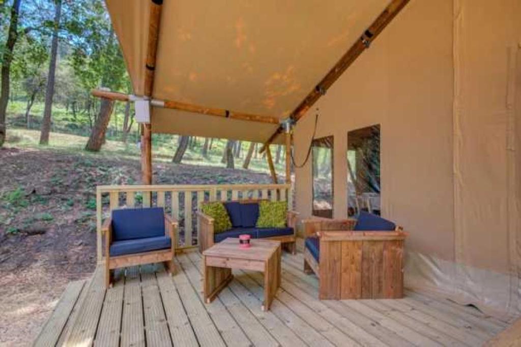 un porche d'une maison avec des chaises et une table dans l'établissement Camping 3 étoiles - Piscine - eebeae, à Mondragon