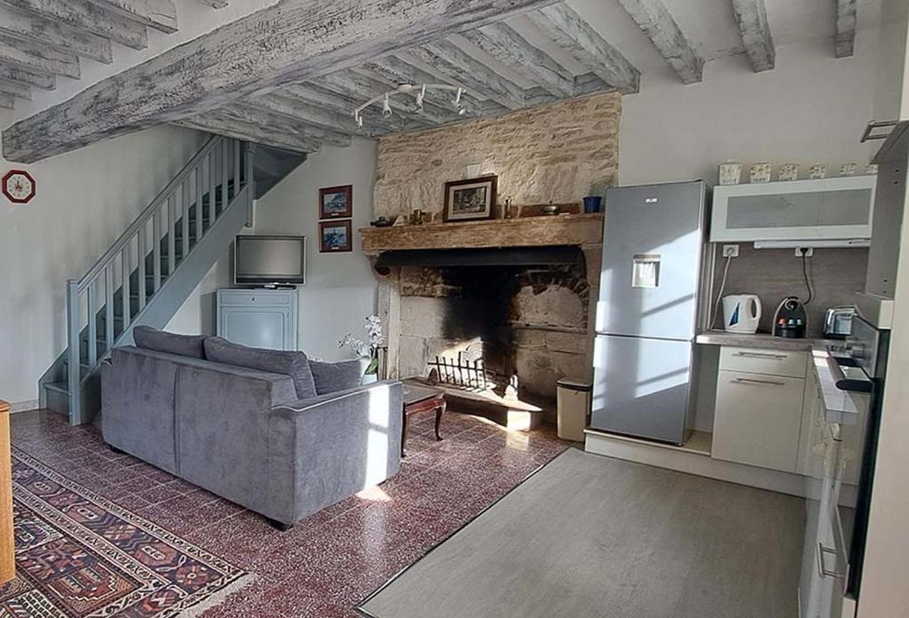 un salon avec un canapé et une cheminée dans l'établissement Domaine du bouloy, à Druyes-les-Belles-Fontaines