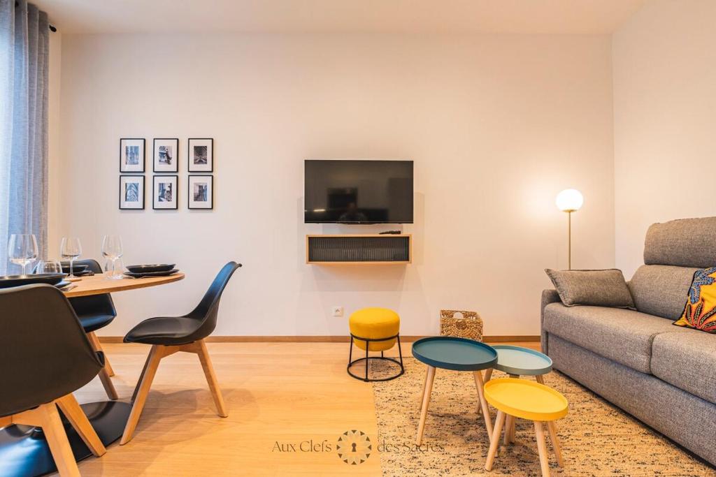 un salon avec un canapé, une table et des chaises dans l'établissement A deux min de la cathédrale T2 Premium Rue Libergier, à Reims