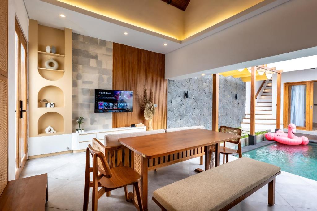 a dining room with a table and a swimming pool at Avyara Villa - Brand NEW, Luxury Tropical with Private Pool in Dalung
