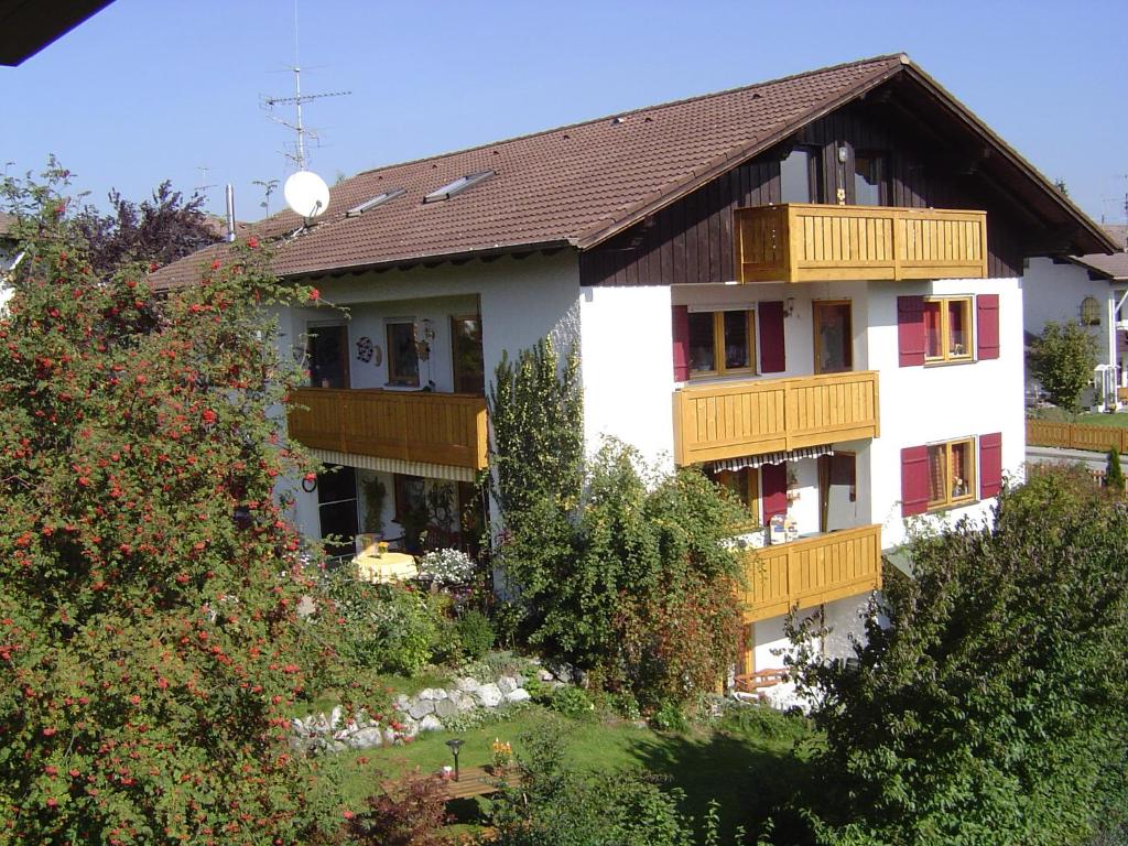 un grand bâtiment blanc avec des balcons en bois dans l'établissement Ferienwohnung Bamberger Gipfelblick, à Hopferau