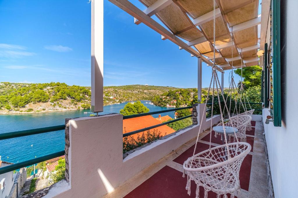 een balkon met stoelen en uitzicht op het water bij Villa Tudor Mit Atemberaubender Aussicht in Bobovišća