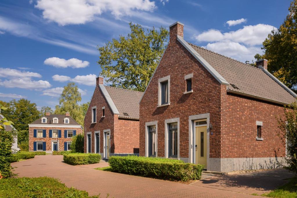 a brick house with a driveway in front at Dormio Resort Maastricht in Maastricht