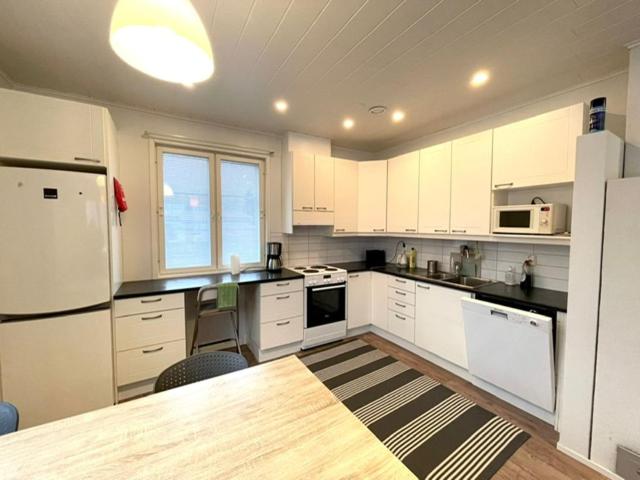 a kitchen with white cabinets and a table in it at Apartment Sorsakuja in Pyhäjoki