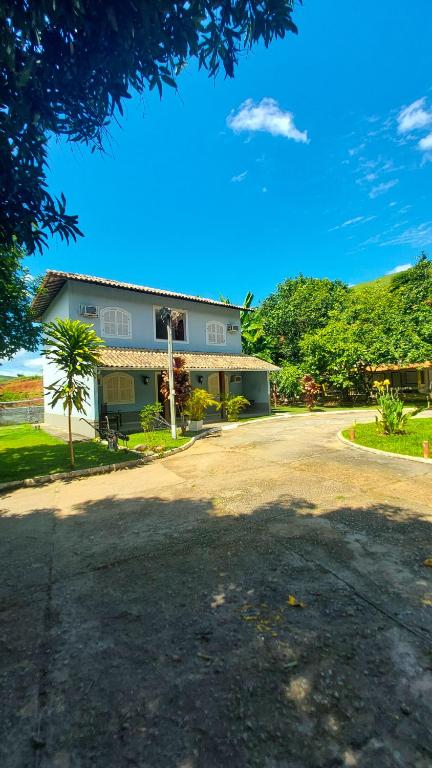 a house on a street with a driveway at Pousada Pouso Alegre in Macuco