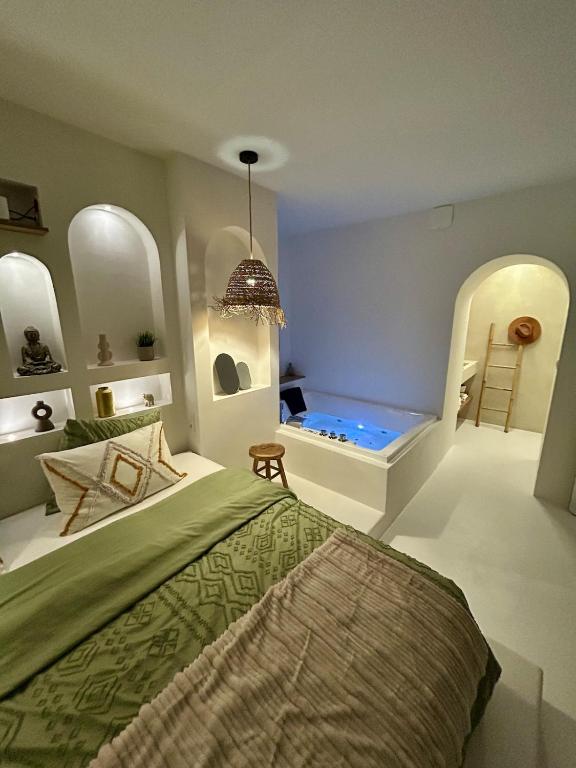 une chambre avec un lit et une baignoire dans l'établissement Bali Suite - Spa Jacuzzi, à Saint Etienne
