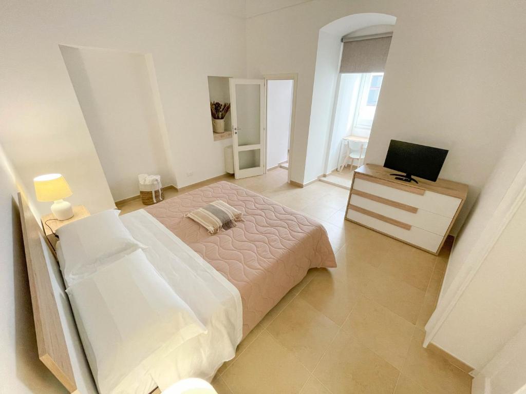 a large white bedroom with a bed and a television at L'Armonia - "La Capasa" in Noci