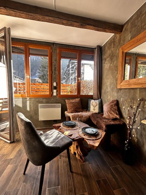 un salon avec une table et une chaise dans l'établissement Jonquille 2 - Centre - Terrasse Privee - Vues, à Chamonix-Mont-Blanc