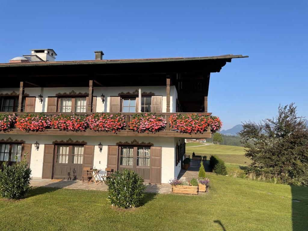 a house with a balcony with flowers on it at Alpennest Blindau in Reit im Winkl