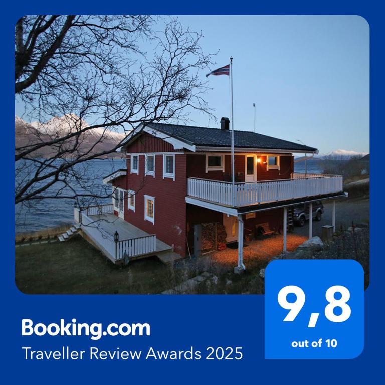 a red house with a flag on top of it at Innsletta holiday home in Harstad