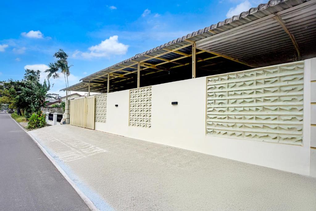 a white building with wooden panels on the side at Hotel O Medan City Center Near Rumah Sakit Bunda Thamrin Formerly Mora Residence in Medan