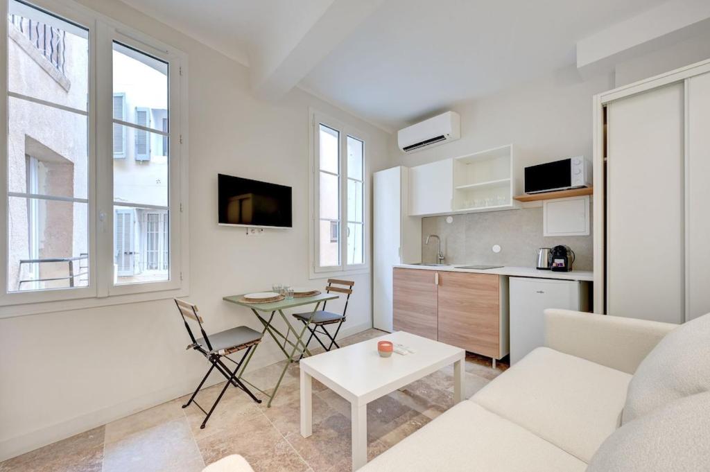 un salon avec un canapé blanc et une table dans l'établissement Le Mirabeau studio au cœur du centre historique - 2eme étage, à Aix-en-Provence