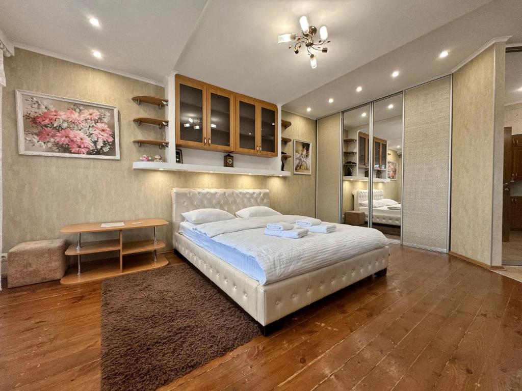 a bedroom with a large bed and a table in it at ApartPoltava Стильна квартира біля Білої Альтанки, серце Полтави in Poltava