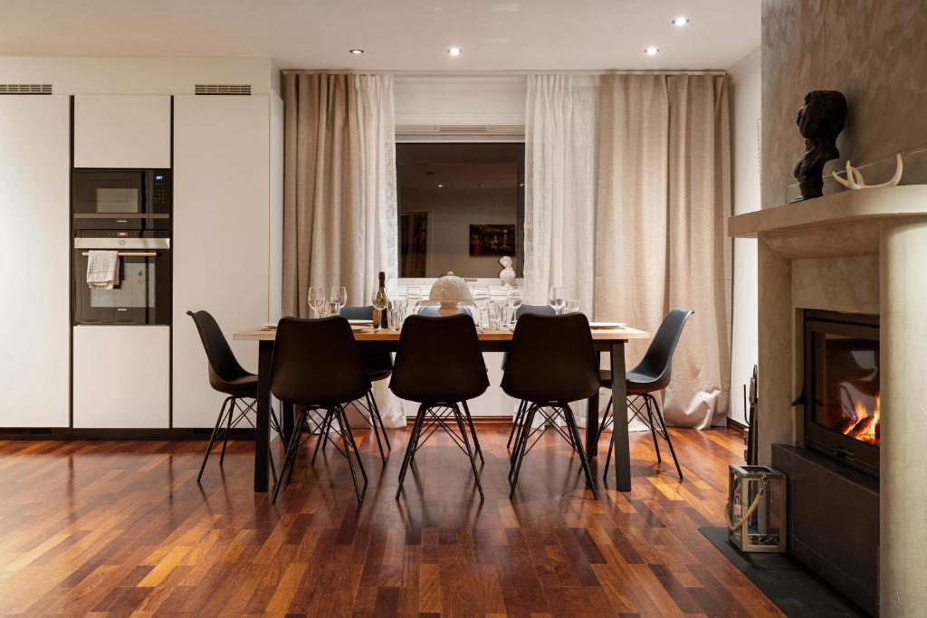 a dining room with a table with chairs and a fireplace at ARCTIC HOMES - Premium Villa Borealis in Tromsø