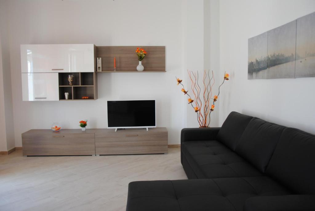 salon z kanapą i telewizorem z płaskim ekranem w obiekcie TD Sesto Piano with Sea View Living Terrace w mieście Monopoli