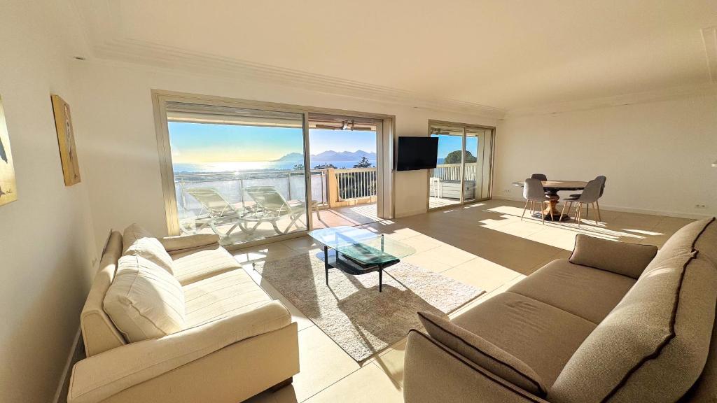 un salon avec un canapé, une télévision et une table dans l'établissement Appartement 2 chambres - Vue panoramique, à Cannes