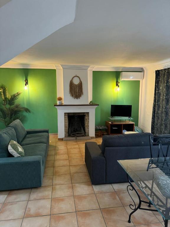 a living room with two couches and a fireplace at Casa Estrelinha Vilamoura in Quarteira