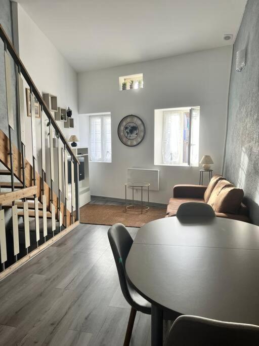 un salon avec une table et un canapé dans l'établissement Charmante maison Drômoise, à Pierrelatte