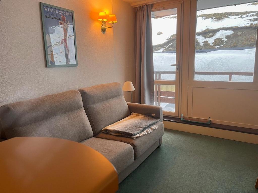 un salon avec un canapé, une table et une fenêtre dans l'établissement T2 appartement au pied des pistes, à Bagnères-de-Bigorre