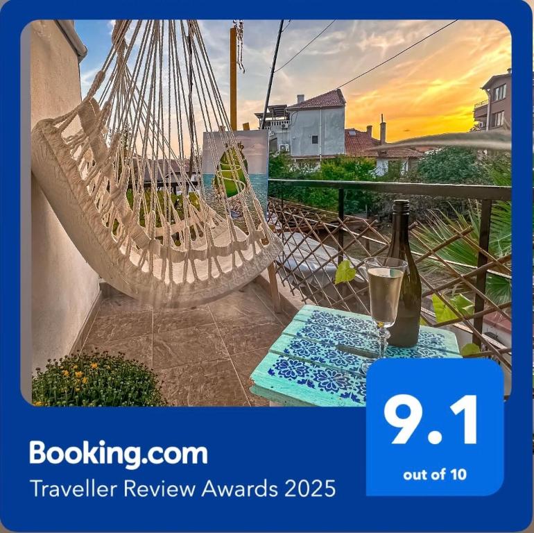 索佐波尔Guest house Hei taka的阳台的吊床,备有一瓶葡萄酒