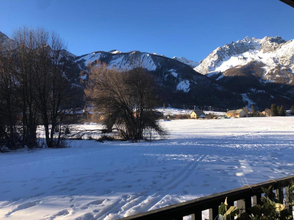 un champ enneigé avec des montagnes en arrière-plan dans l'établissement Monetiers, au Monêtier-les-Bains