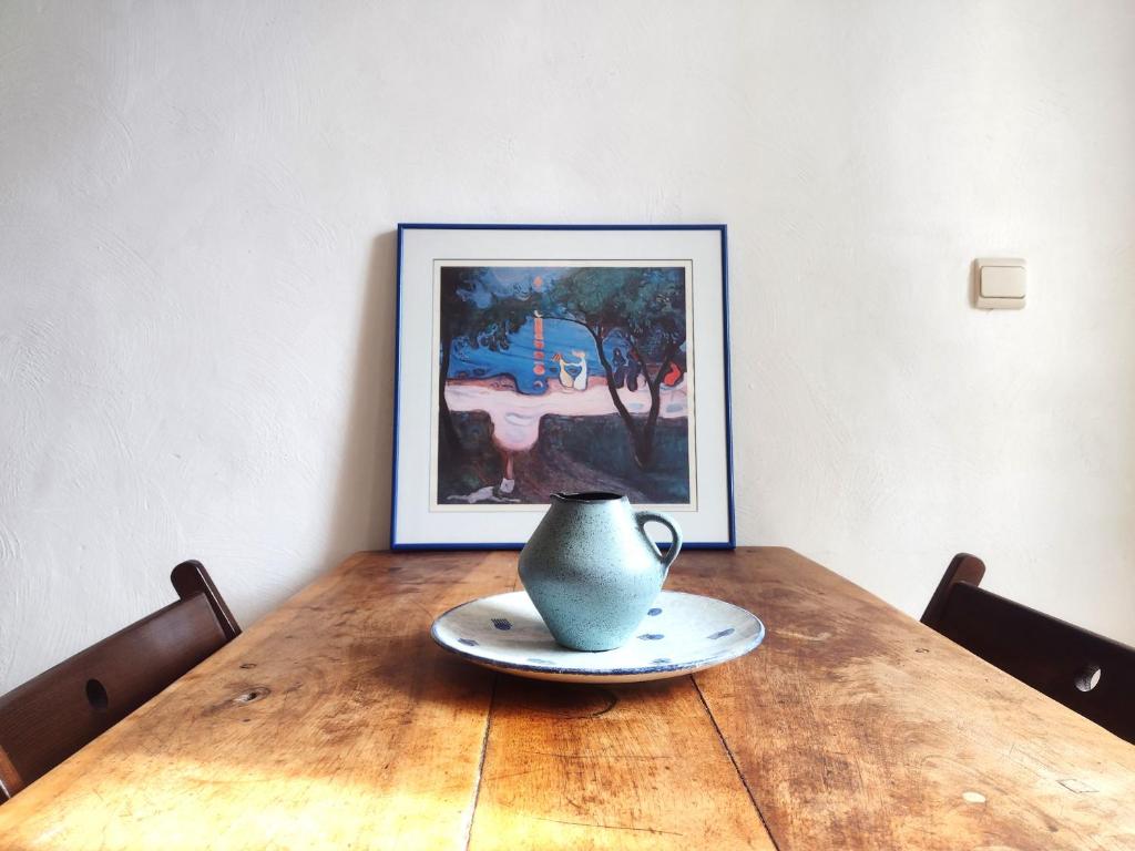 stół z wazonem i obrazem w obiekcie Studio Campanule Provence Verdon w mieście Riez