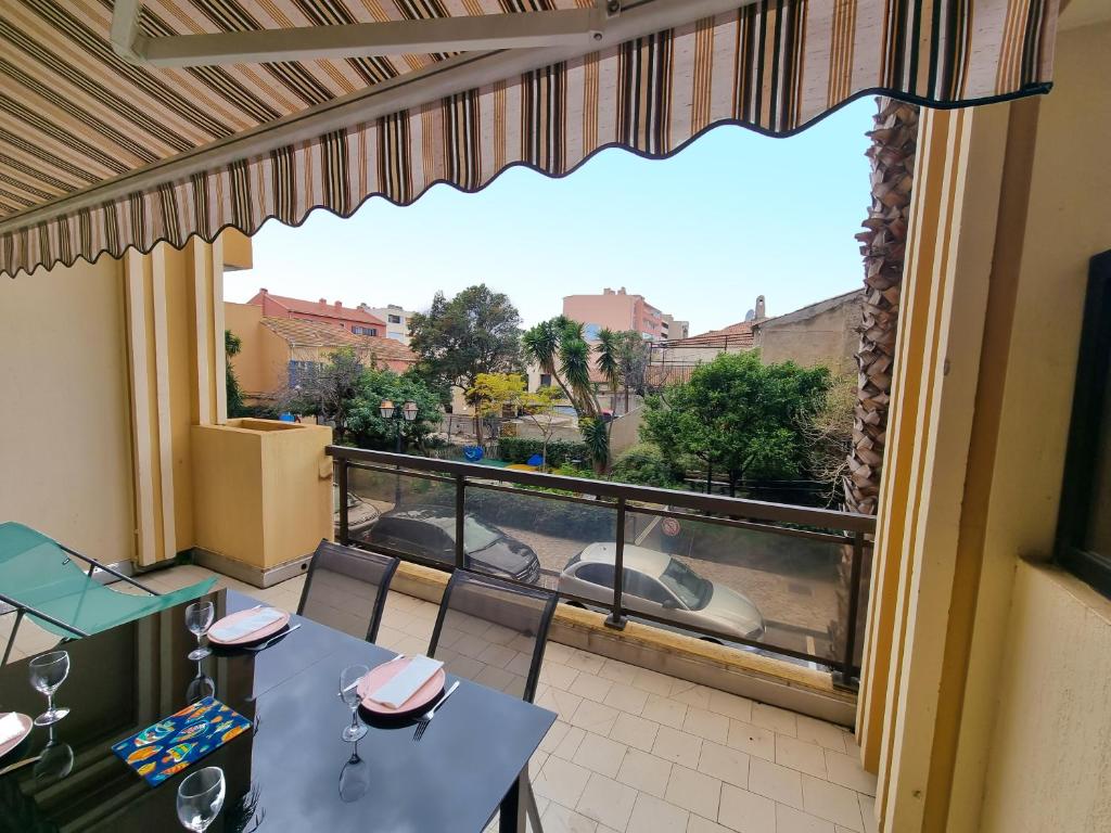 un balcon avec une table et des chaises et une vue dans l'établissement L'escapade - T2 en centre ville avec terrasse, clim et wifi, au Lavandou
