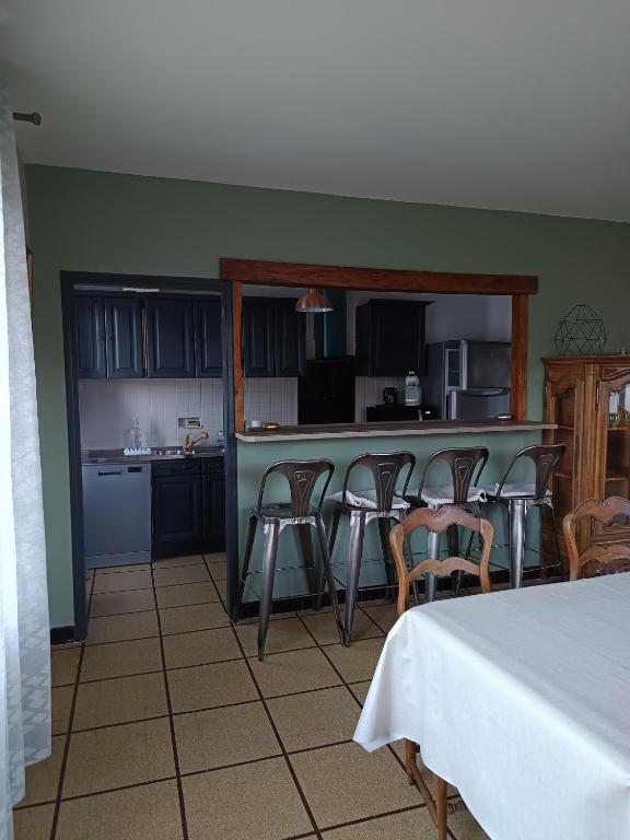 une cuisine avec un groupe de chaises et un comptoir dans l'établissement Appartement de village avec grande terrasse, à Malaucène