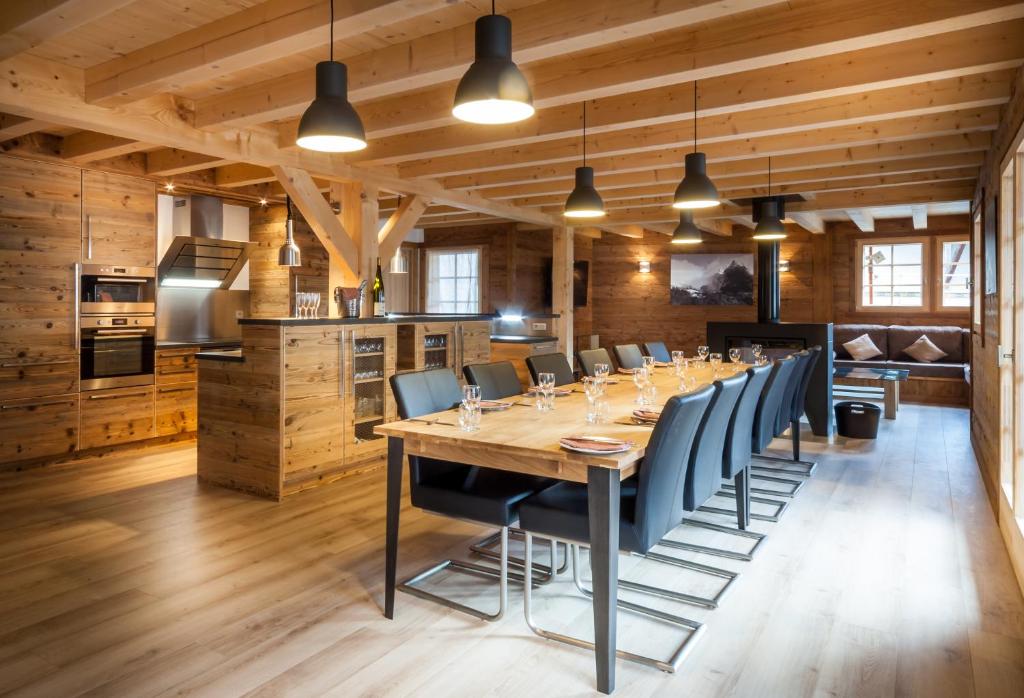 una grande sala da pranzo con un lungo tavolo e sedie di Les Couadzous Samoëns Centre, Sauna, Jacuzzi, 6 chambres, 7 salles de bains, 16 pers 250 m2 a Samoëns