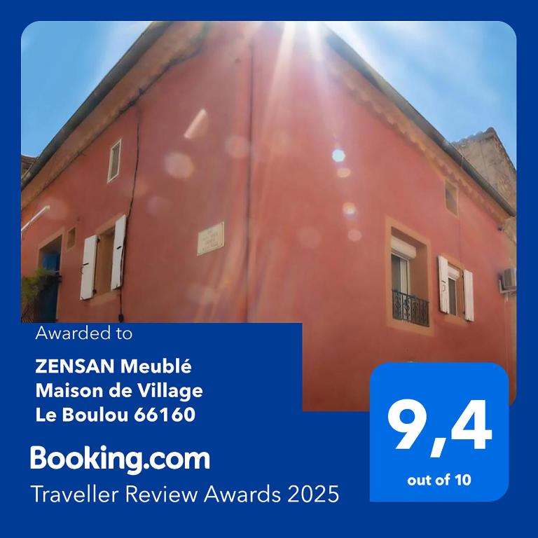 Un bâtiment rouge où le soleil brille dans l'établissement ZENSAN Meublé Maison de Village Le Boulou 66160, au Boulou