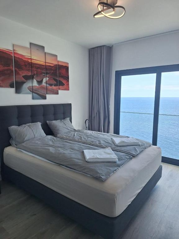 a bedroom with a bed with a view of the ocean at Cliff Residence Ocean View in Gaula