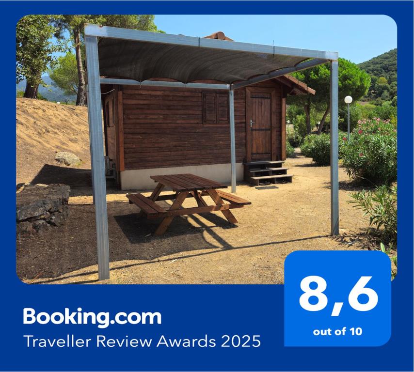 un abri de pique-nique avec une table de pique-nique sous celui-ci dans l'établissement Camping Les Couchants, à Casaglione