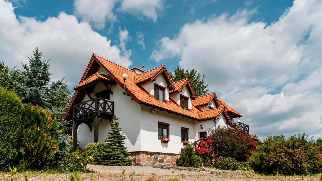 una casa con tetto arancione di Willa Zasypane Mazury, Sun & Snow a Orło