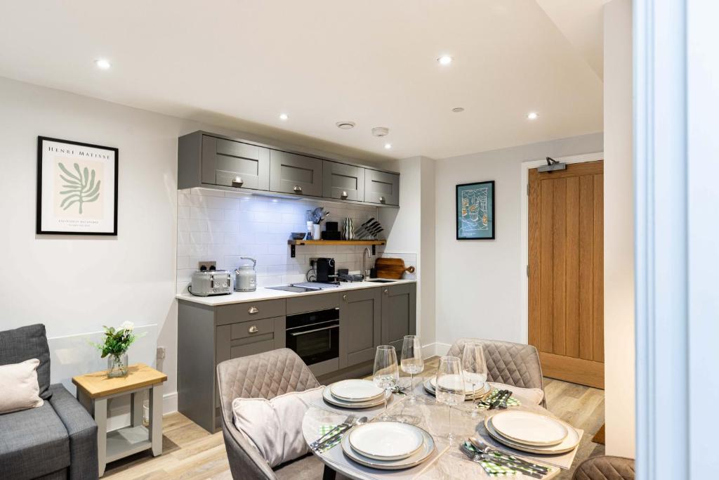 a kitchen and living room with a table and chairs at Rock Mill 1 Bed Apartment 32 in Stoney Middleton