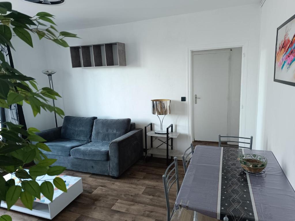 un salon avec un canapé bleu et une table dans l'établissement Mikelimoges, à Limoges