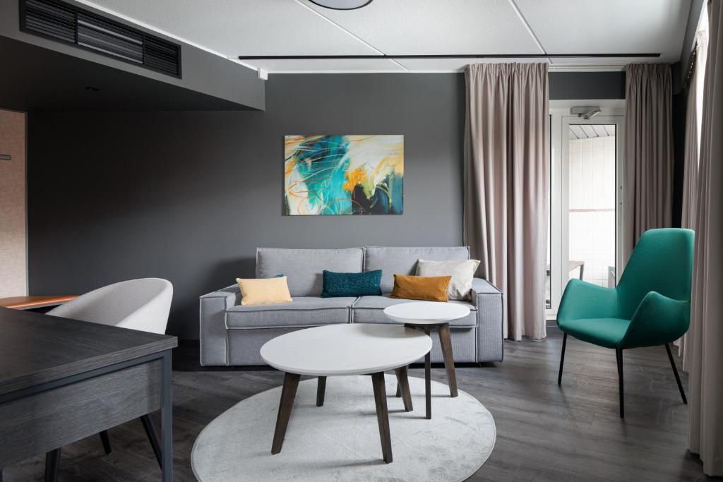 a living room with a couch and a table and chairs at Original Sokos Hotel Vantaa in Vantaa