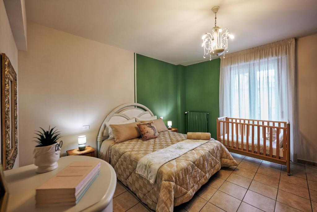 une chambre avec un lit et des murs verts et une table dans l'établissement The Vintage House in San Giovanni Rotondo, à San Giovanni Rotondo