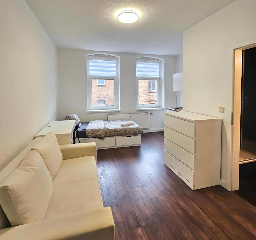 ein Wohnzimmer mit einer Couch und einem Bett in der Unterkunft Checkpoint LS 65 Mikroapartments für ein bis vier Personen in Büschdorf