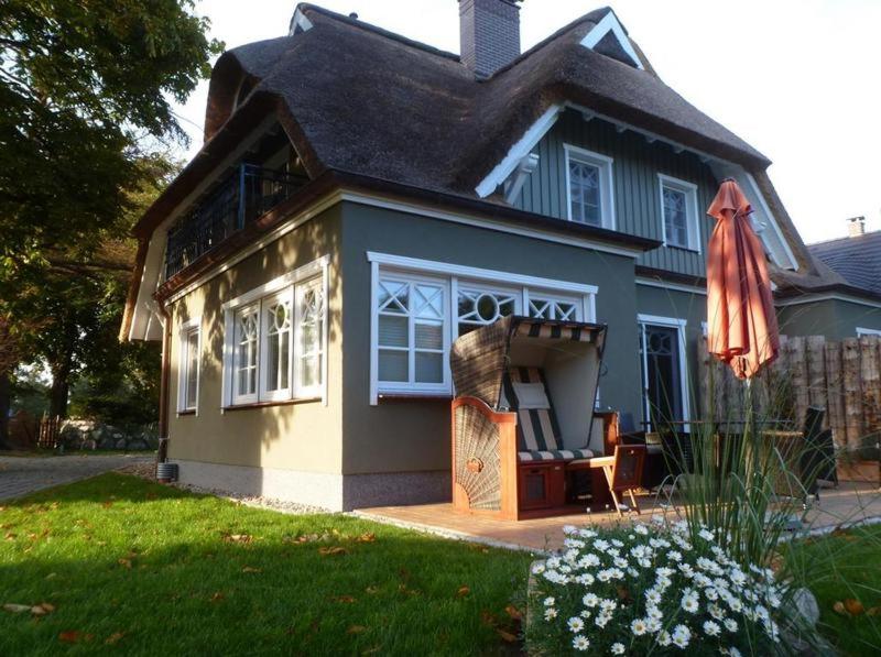 a small blue house with a chair and an umbrella at Piratenhus in Prerow