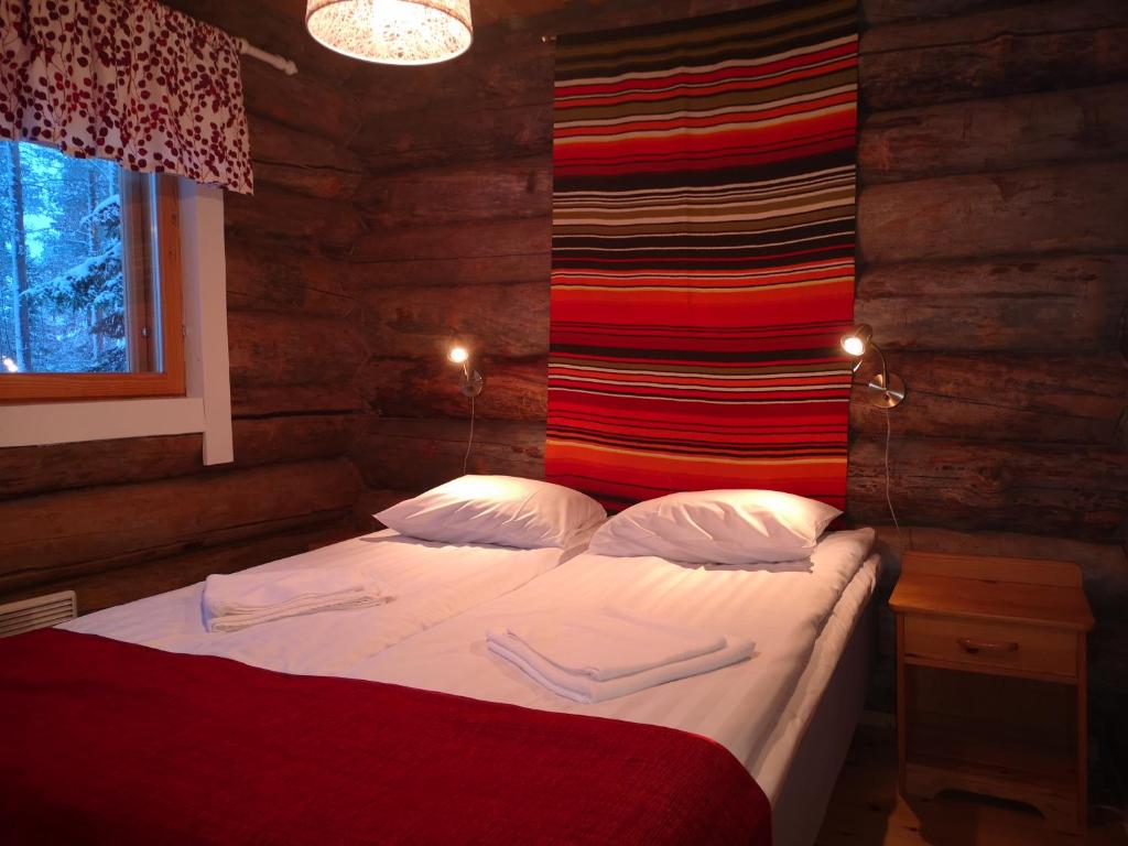 a bedroom with a bed with two towels on it at Ukonloma Salmilampi in Rovaniemi