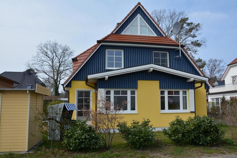 uma casa amarela e azul com em Hagens Hus em Prerow