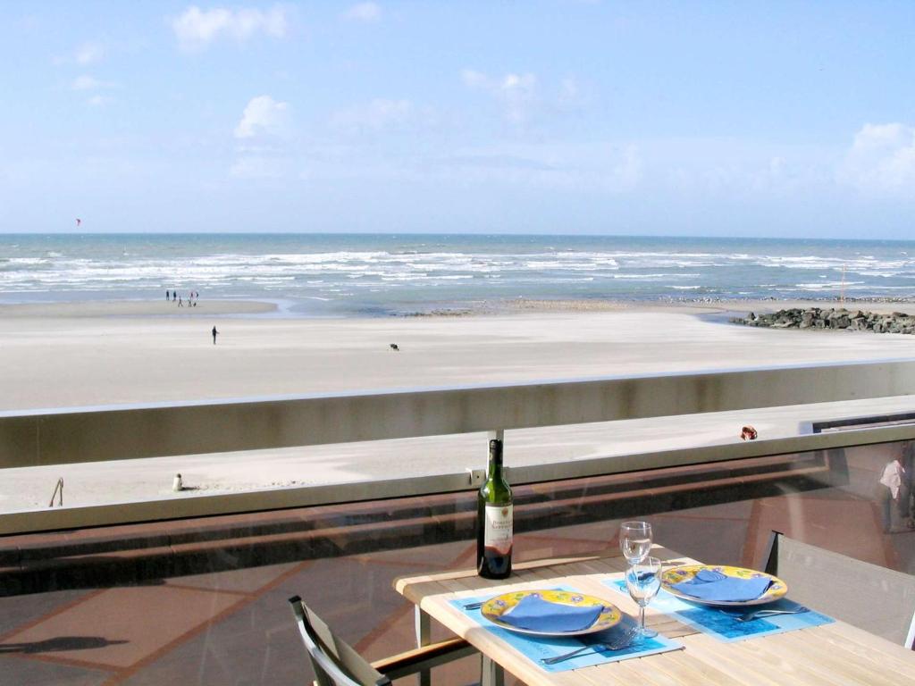 - une table avec une bouteille de vin et une vue sur la plage dans l'établissement T2 Cabine avec Balcon et WIFI sur la Digue de Wimereux - FR-1-675-39, à Wimereux