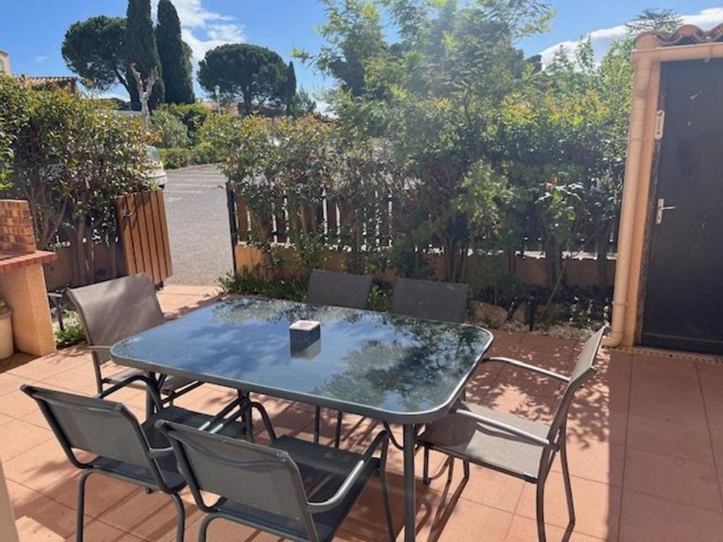 une table et des chaises assises sur une terrasse dans l'établissement Appartement climatisé avec piscine proche plage, commerces et golf - 6 pers - FR-1-749-51, au Cap d'Agde