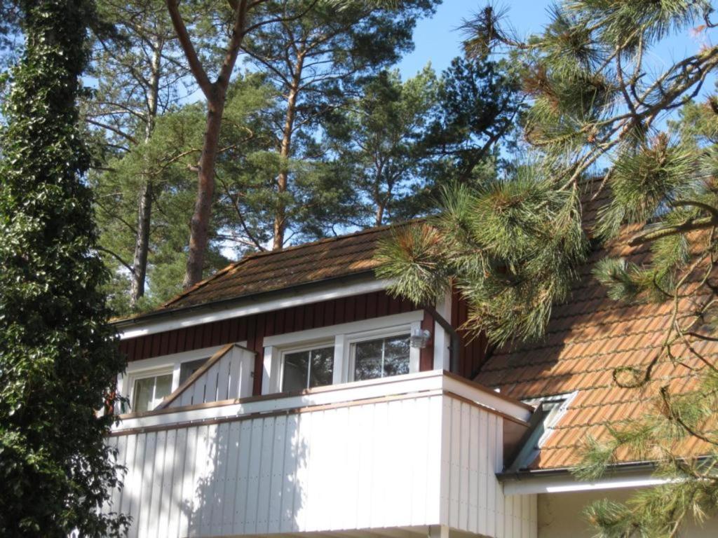 プレローにあるStrandlustの茶色と白の屋根と木々のある家